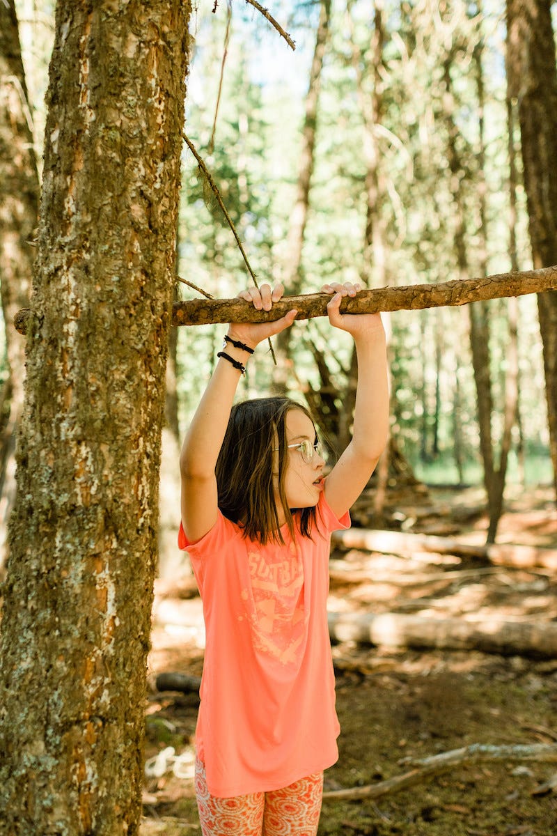 Kid holding up stick in the forest