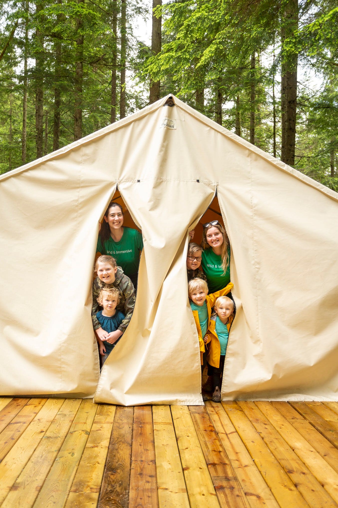 Group looking out the doors of a camp tent and Wild & Immersive in Maple Ridge