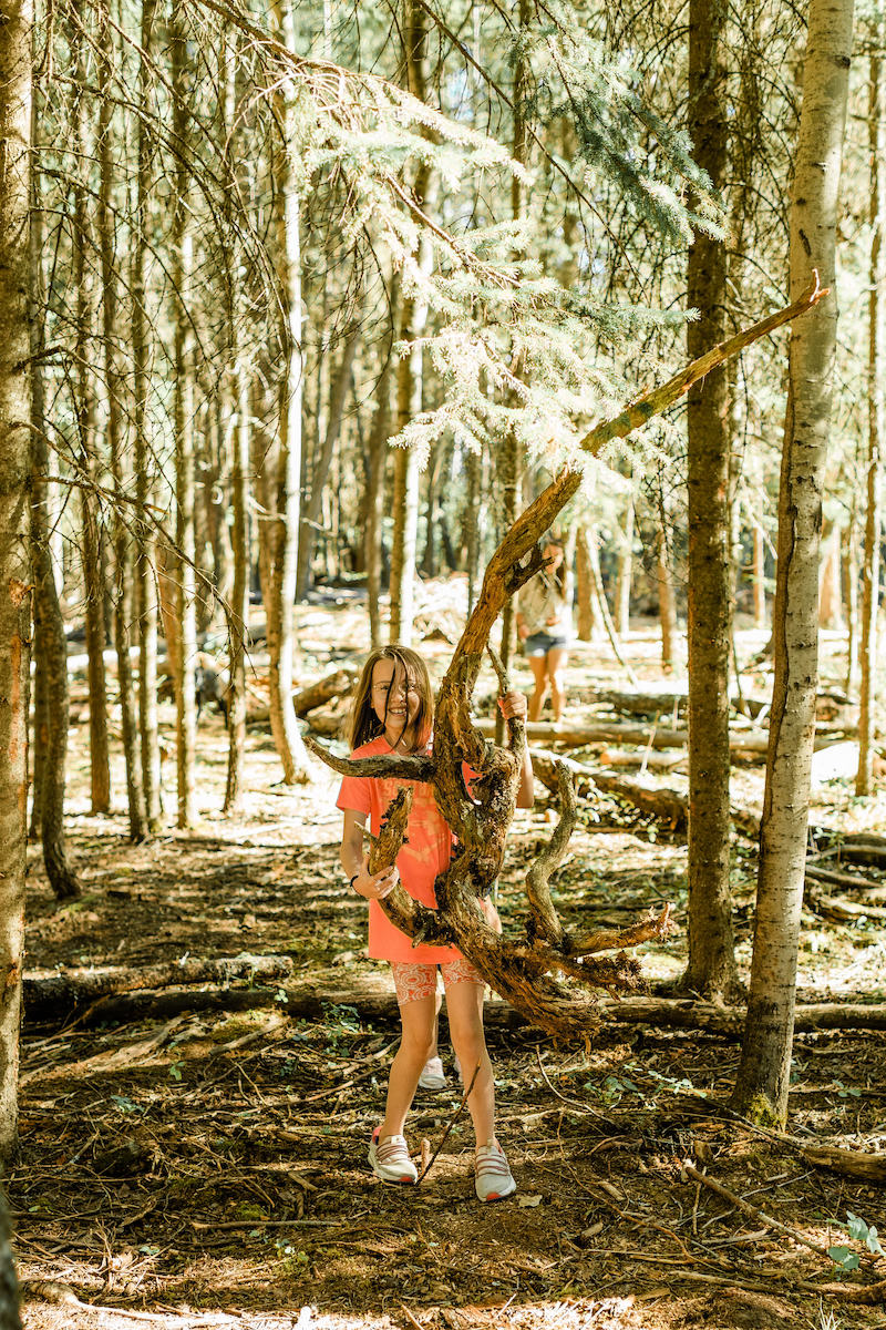 Kid holding up large stick in the forest