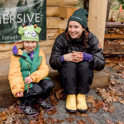 Kid and leader smiling at Wild & Immersive forest camp