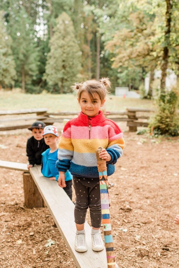 young girl at outdoor kids program wearing a thick sweater and warm leggings