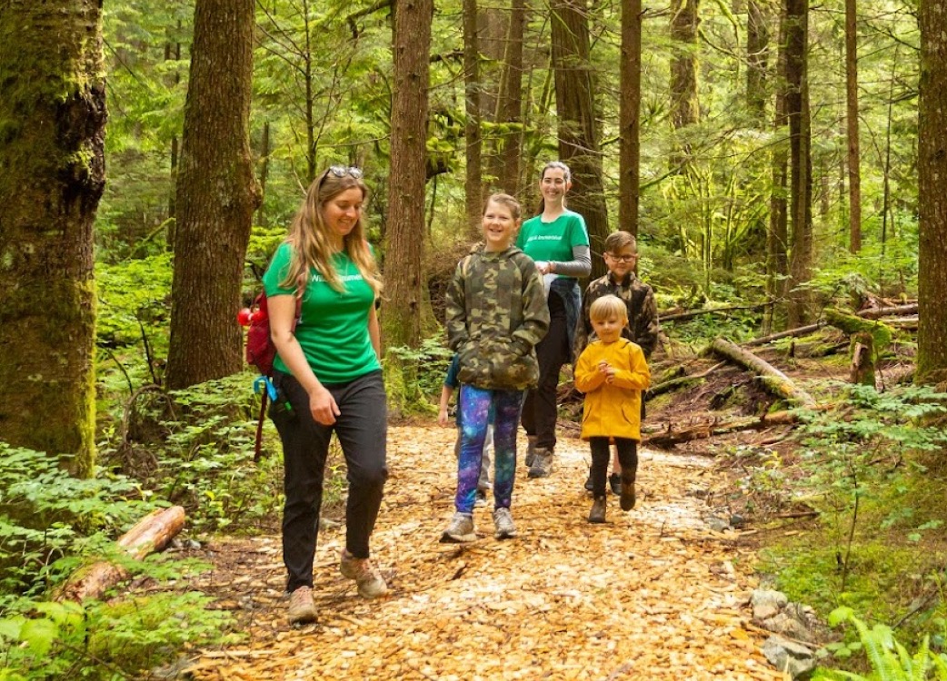 Kids and the Wild & Immersive team members on a hike through the forest in the spring