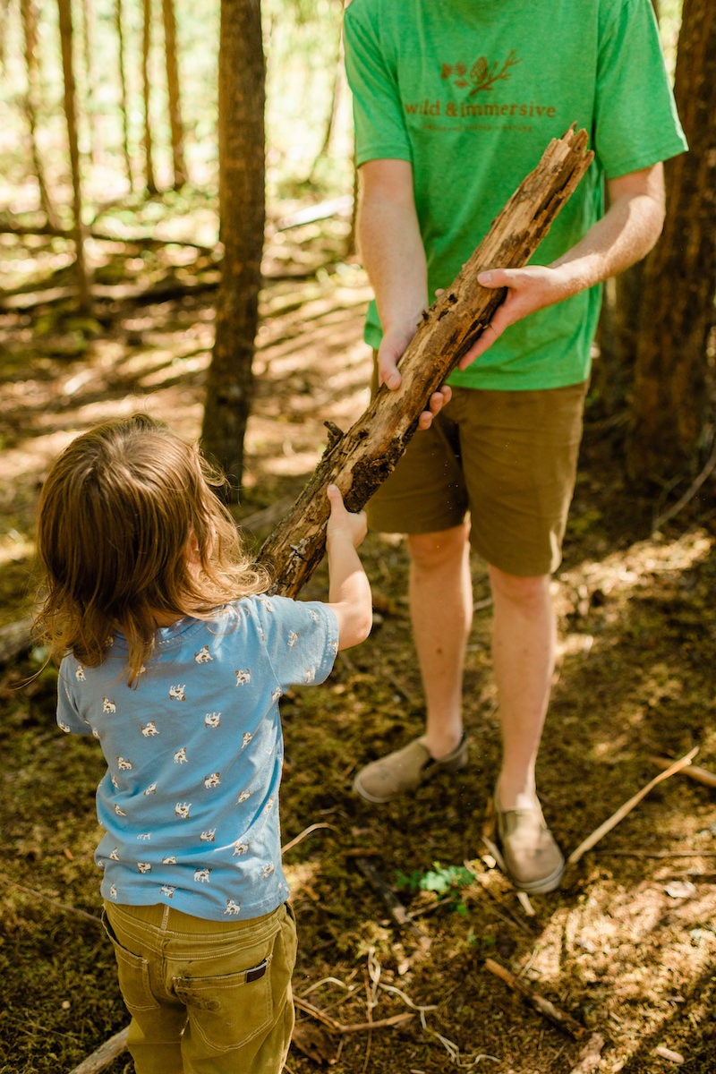 Kid holding up stick in the forest