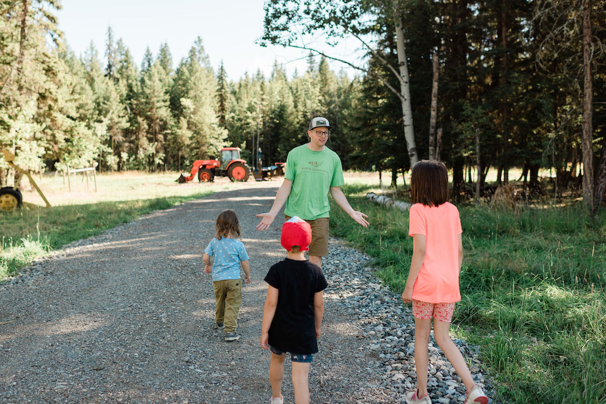 Kids following leading along forest path at Williams Lake camp