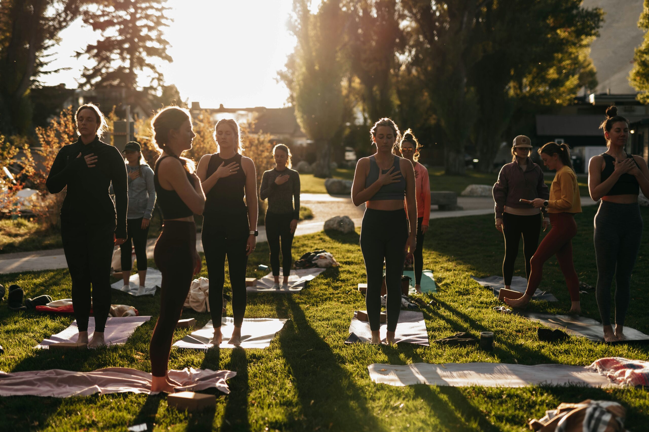 A group of people at outdoor corporate retreats doing yoga together.