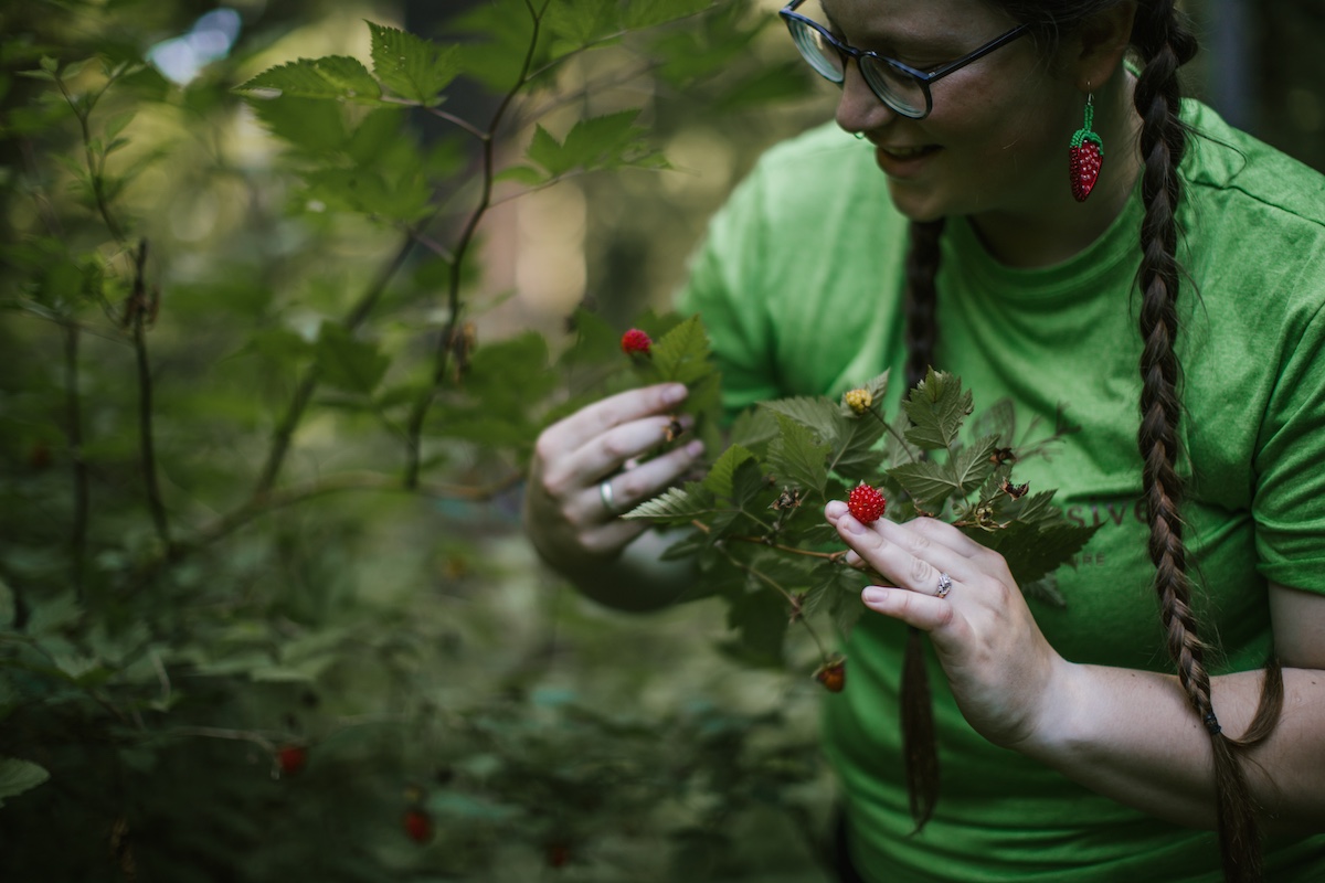 Wild & Immersive team member holding up wild raspberries