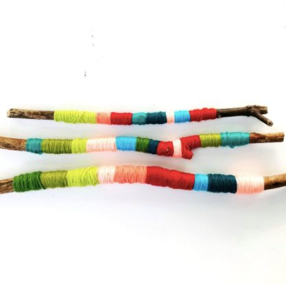 sticks with yarn wrapped around in colourful stripes of red, greens, blues, and greens